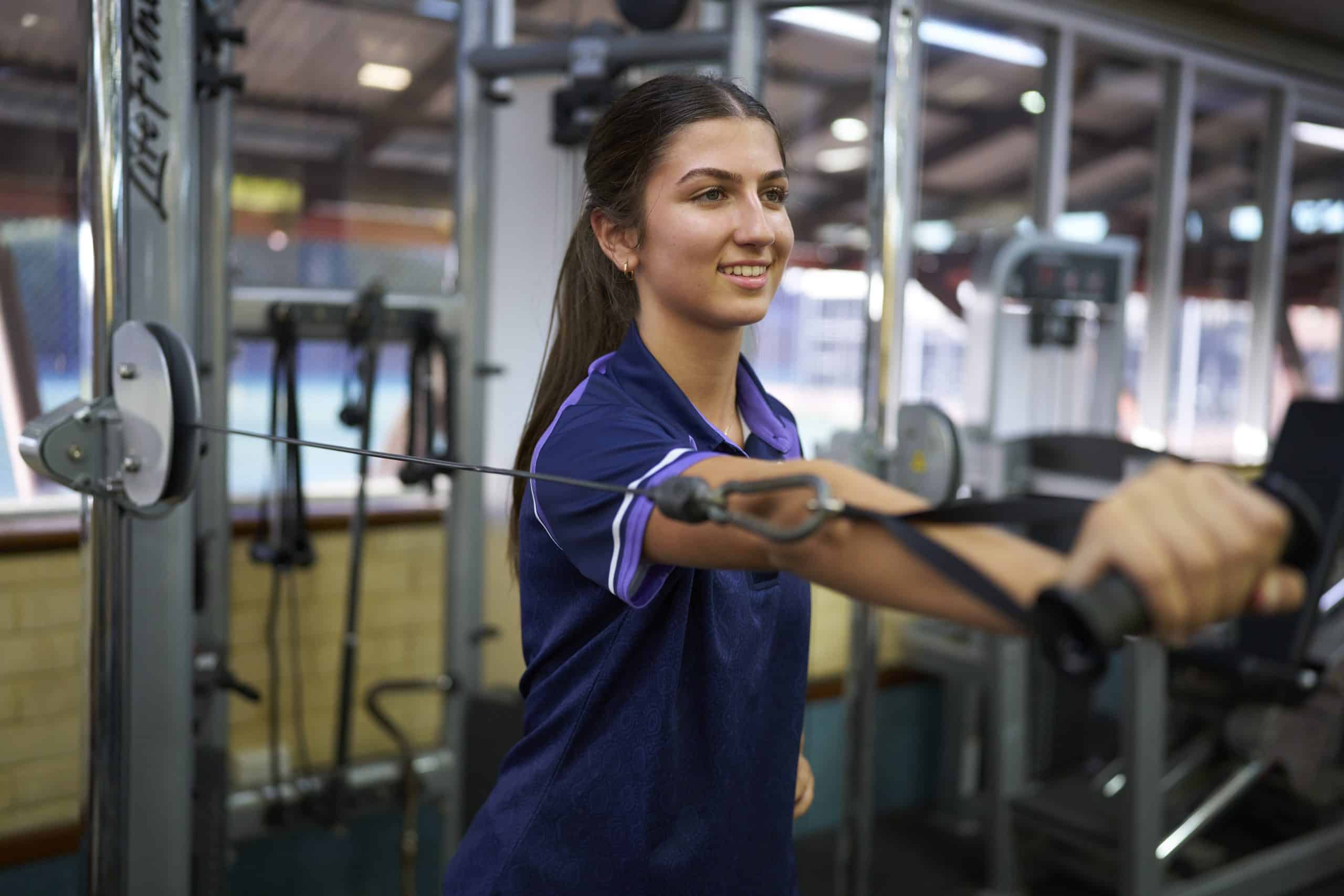 Woman using cable machine in gym.